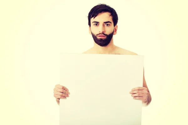 Jovem sem camisa homem segurando banner vazio . — Fotografia de Stock