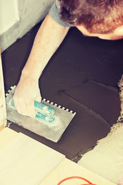 Tiler installs ceramic tiles — Stock Photo, Image