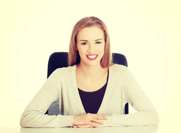Beautiful happy, smiling woman sitting by a desk. — ストック写真