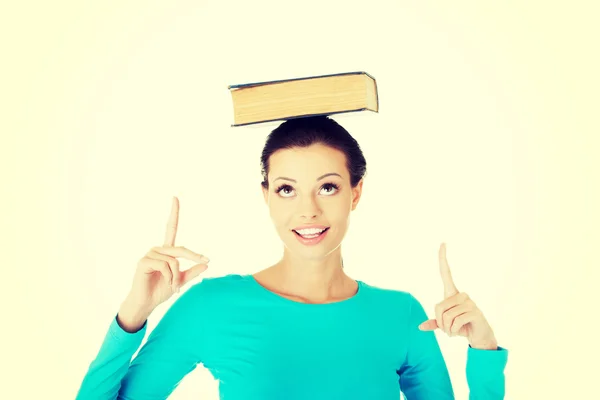 Portrait of a woman holding book on her head — Stock Photo, Image