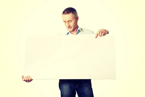 Handsome man holding an empty banner — Stock Photo, Image