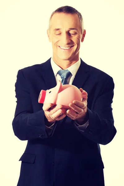 Piggybank を保持している陽気な実業家の肖像画 — ストック写真