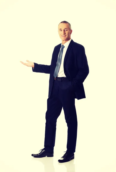 Full length smiling businessman holding copyspace — Stock Photo, Image