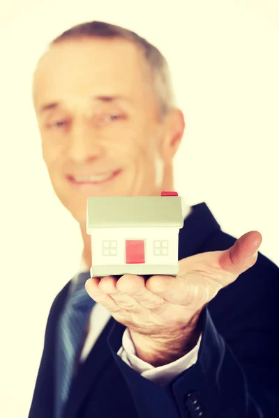 Zakenman holding house model — Stockfoto