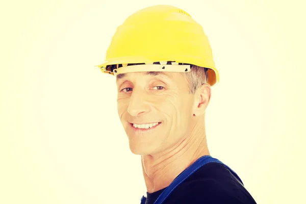 Улыбающийся строитель с защитным шлемом — стоковое фото