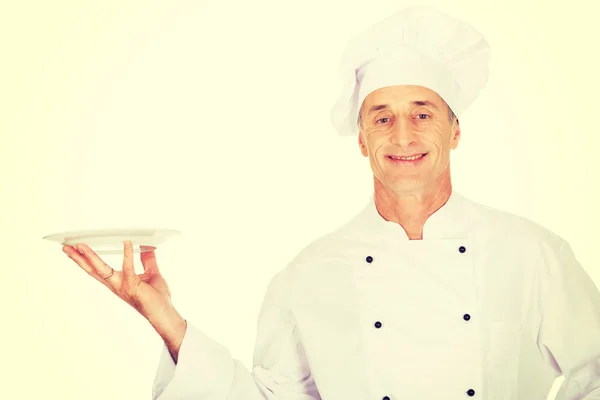 Шеф-кухар тримає білу порцелянову тарілку — стокове фото