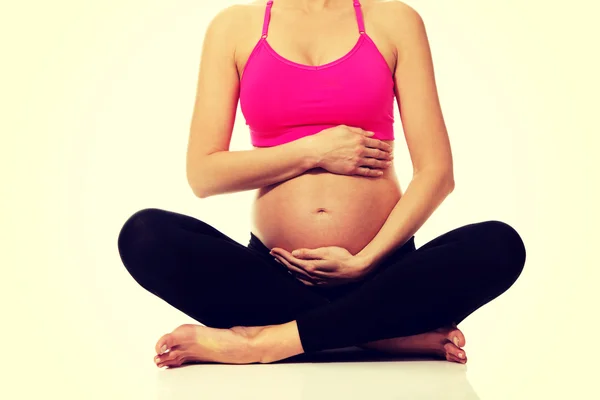 Kobieta w ciąży siedzi krzyż legged — Zdjęcie stockowe