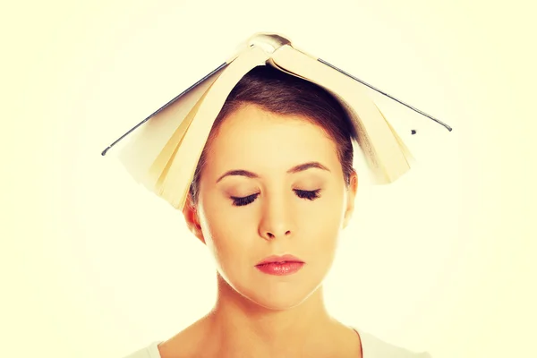 Femme tenant livre sur la tête — Photo