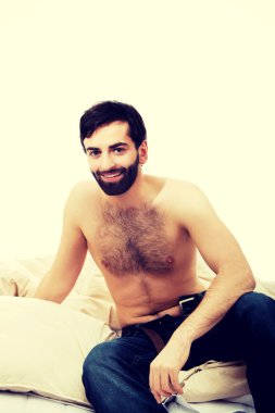 Genç adam yatakta oturuyor..