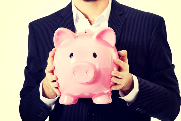 Businessman holding a piggy bank. — Stock Photo, Image