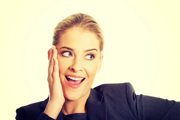 Portrait of amazed businesswoman touching chin — Stockfoto