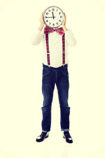 Man wearing suspenders hiding behind big clock. — Stock Photo, Image