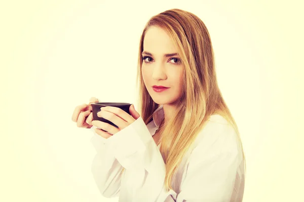 Vrouw in shirt met lange mouwen drinken koffie. — Stockfoto