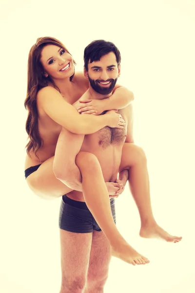 Man carrying girlfriend on his back. — Stock Photo, Image