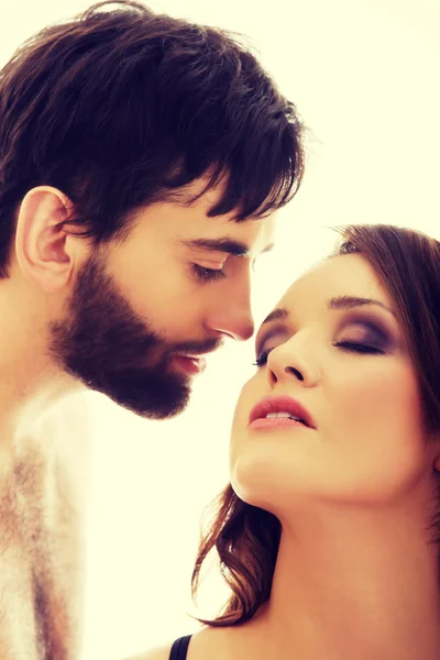 Shirtless man whispering to womans ear. — Stock Photo, Image