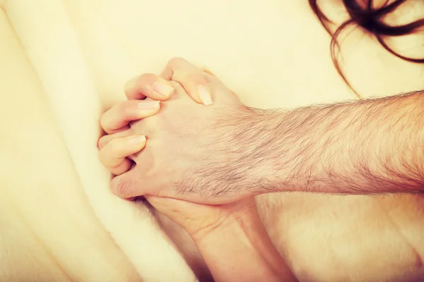 Hands of female and male lying on bed — Stock Photo, Image