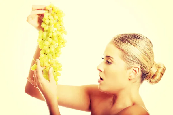 Side view of nude woman holding grapes — Stock Photo, Image