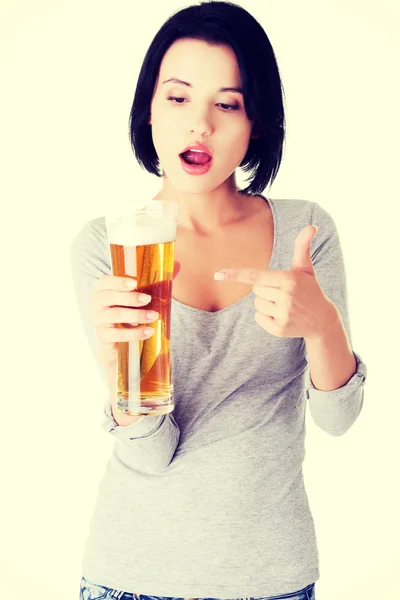 Femme surprise tenant un verre de bière — Photo