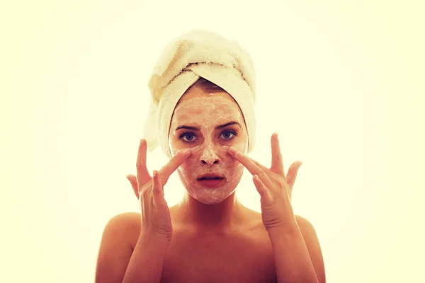 Mujer aplicando una crema en su cara — Foto de Stock