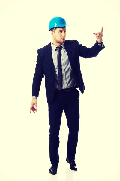 Happy businessman in helmet points his finger up. — Stock Photo, Image