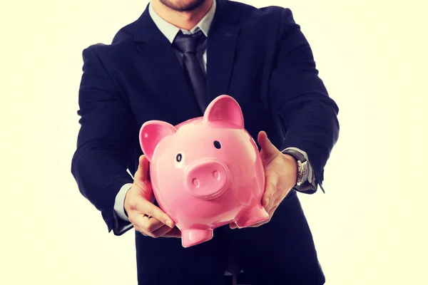 Affärsman som innehar en piggybank. — Stockfoto