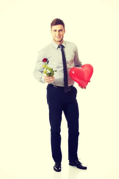 Young man with a red rose and heart balloon. — Stock Photo, Image