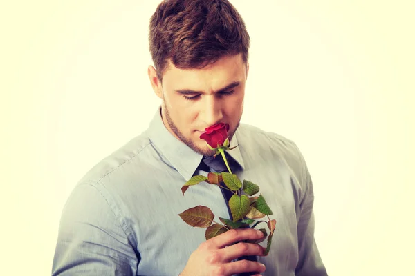 Красивий чоловік тримає червону троянду . — стокове фото