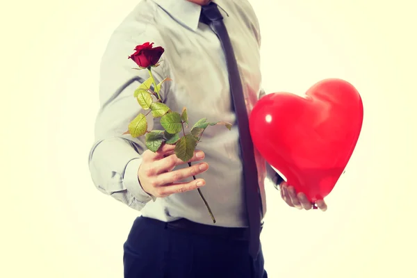 Jonge man met een rode roos en hart ballon. — Stockfoto