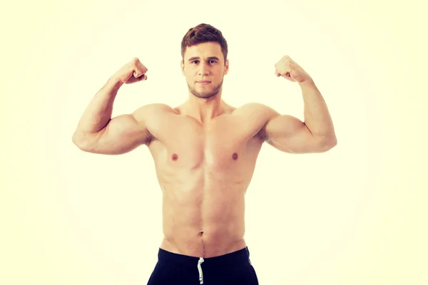 Giovane atletico uomo mostrando i muscoli . — Foto Stock