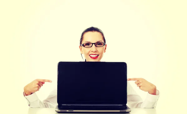 Vrouw met laptop punten op het scherm. — Stockfoto