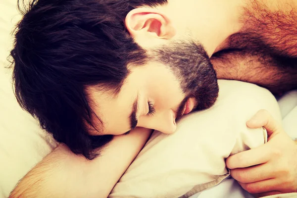 Junger Mann schläft im Bett. — Stockfoto