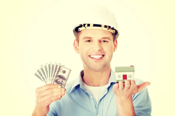 Construction man holding house model and money — Stock Photo, Image