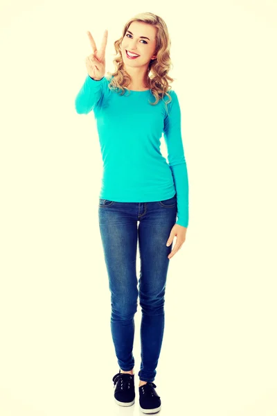 Young woman showing victory sign — Stock Photo, Image