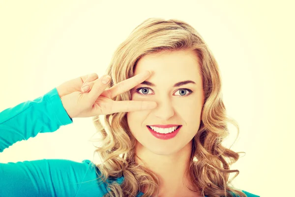 Junge Frau zeigt Siegeszeichen — Stockfoto