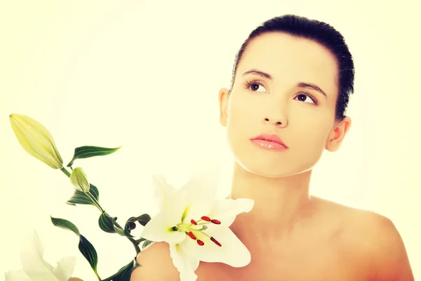 Frau mit gesunder Haut und Lilienblüte — Stockfoto