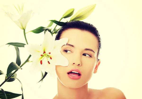 Frau mit gesunder Haut und Lilienblüte — Stockfoto