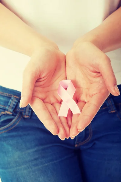 Hands holding pink breast cancer awareness ribbon — Stock Photo, Image
