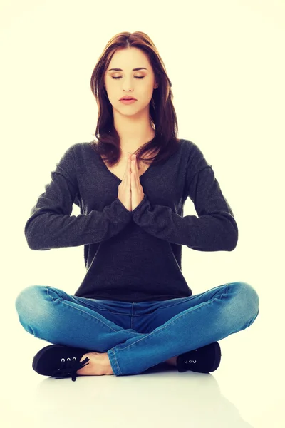 Pretty student girl meditating in lotus pose. — Stock Photo, Image