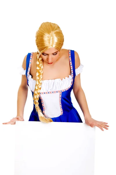 Žena nosí bavorské oblečení drží prázdný nápis. — Stock fotografie