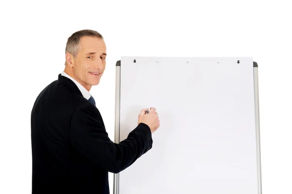 Scrivere un dirigente maschio su un flipchart — Foto Stock