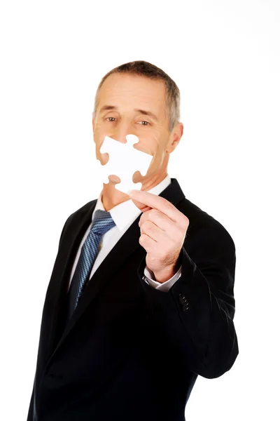 Smart businessman holding a puzzle — Stock Photo, Image