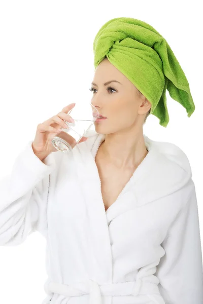 Woman in bathrobe drinks water. — Stock Photo, Image