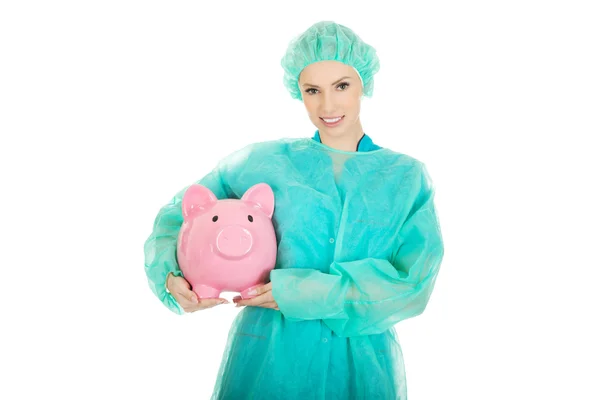 Medico femminile con salvadanaio rosa . — Foto Stock