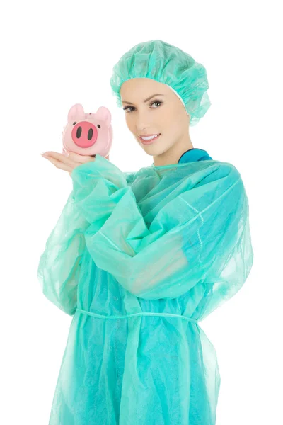 Ärztin mit rosa Sparschwein. — Stockfoto