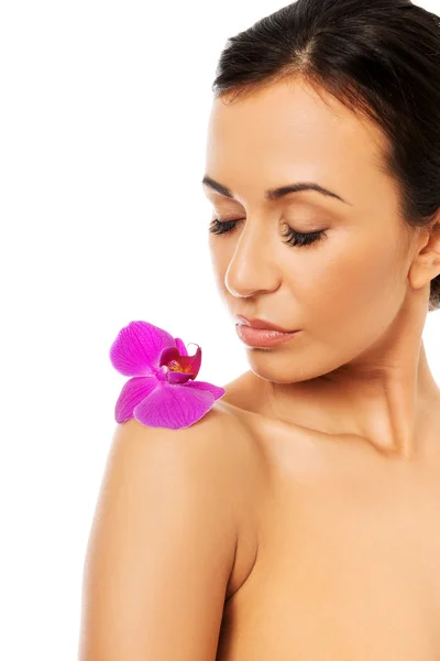 Woman with orchid petal on shoulder — Stok fotoğraf