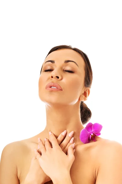 Woman with orchid petal on shoulder — Stockfoto