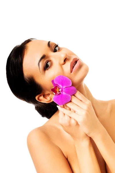 Woman with orchid petal near face — Stockfoto