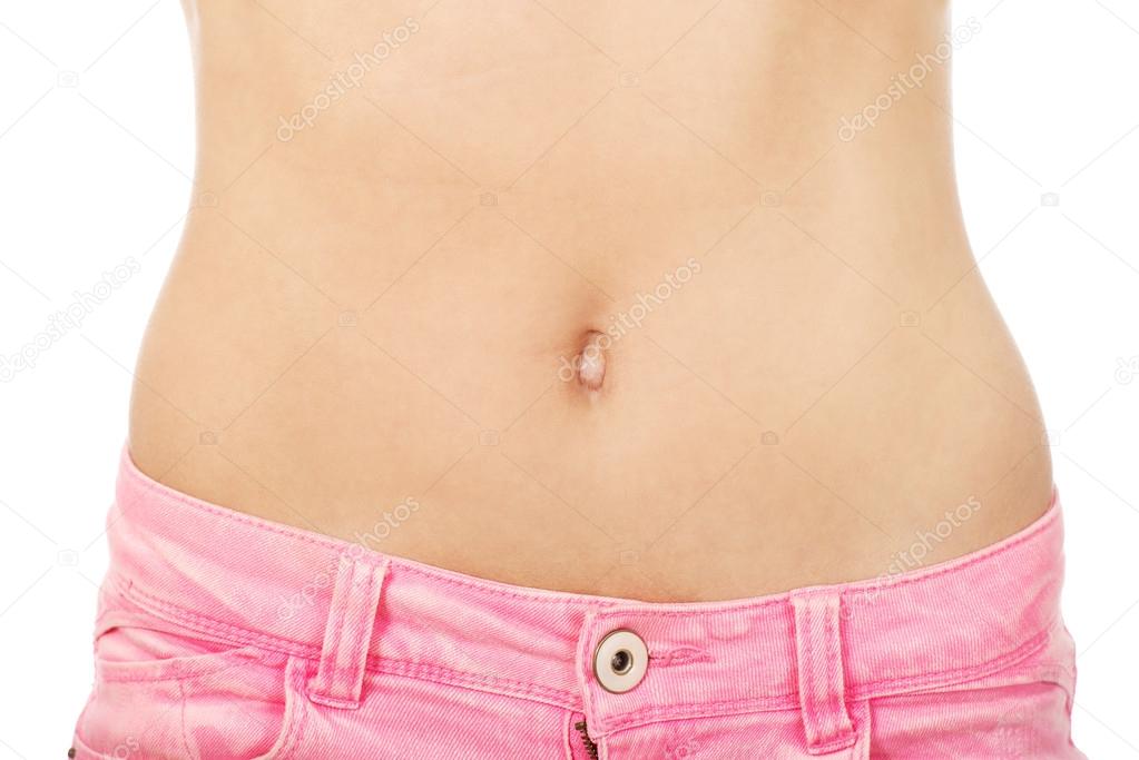 Slim woman in  jeans showing belly.