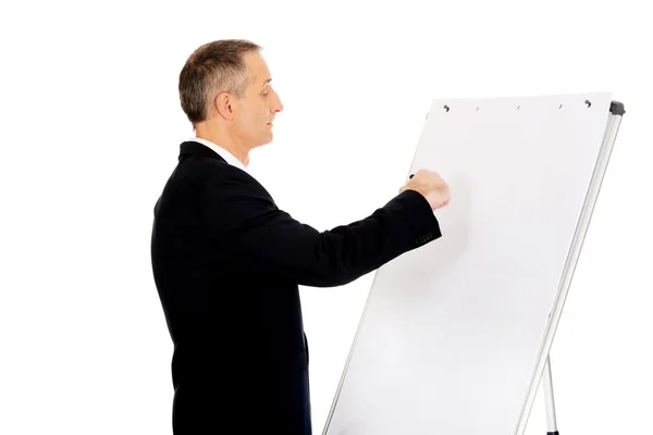Αρσενικό εκτελεστικό γράφοντας σε ένα flip chart — Φωτογραφία Αρχείου