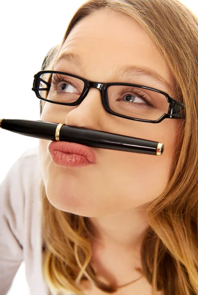 Young woman with pen on mouth — Stock Photo, Image